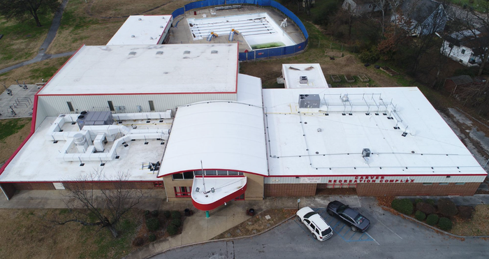 An aerial view of a large building with a white roof