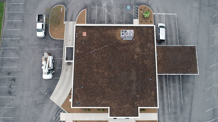 An aerial view of a building with cars parked in front of it