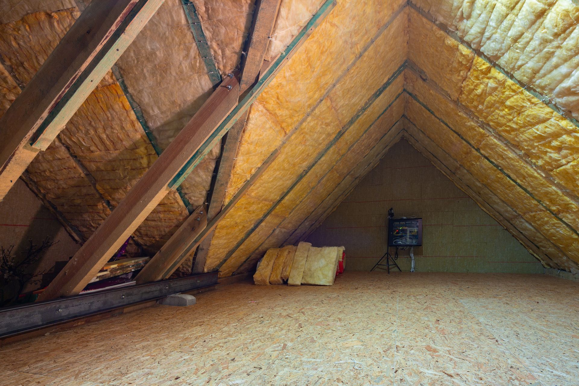 Un grenier avec beaucoup d'isolation et des poutres en bois.