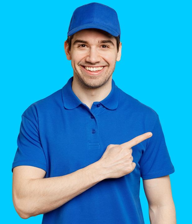 Un homme en chemise bleue et chapeau pointe quelque chose.