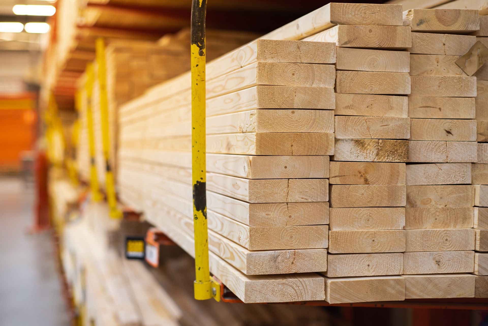 Un entrepôt rempli de nombreuses planches de bois empilées les unes sur les autres.