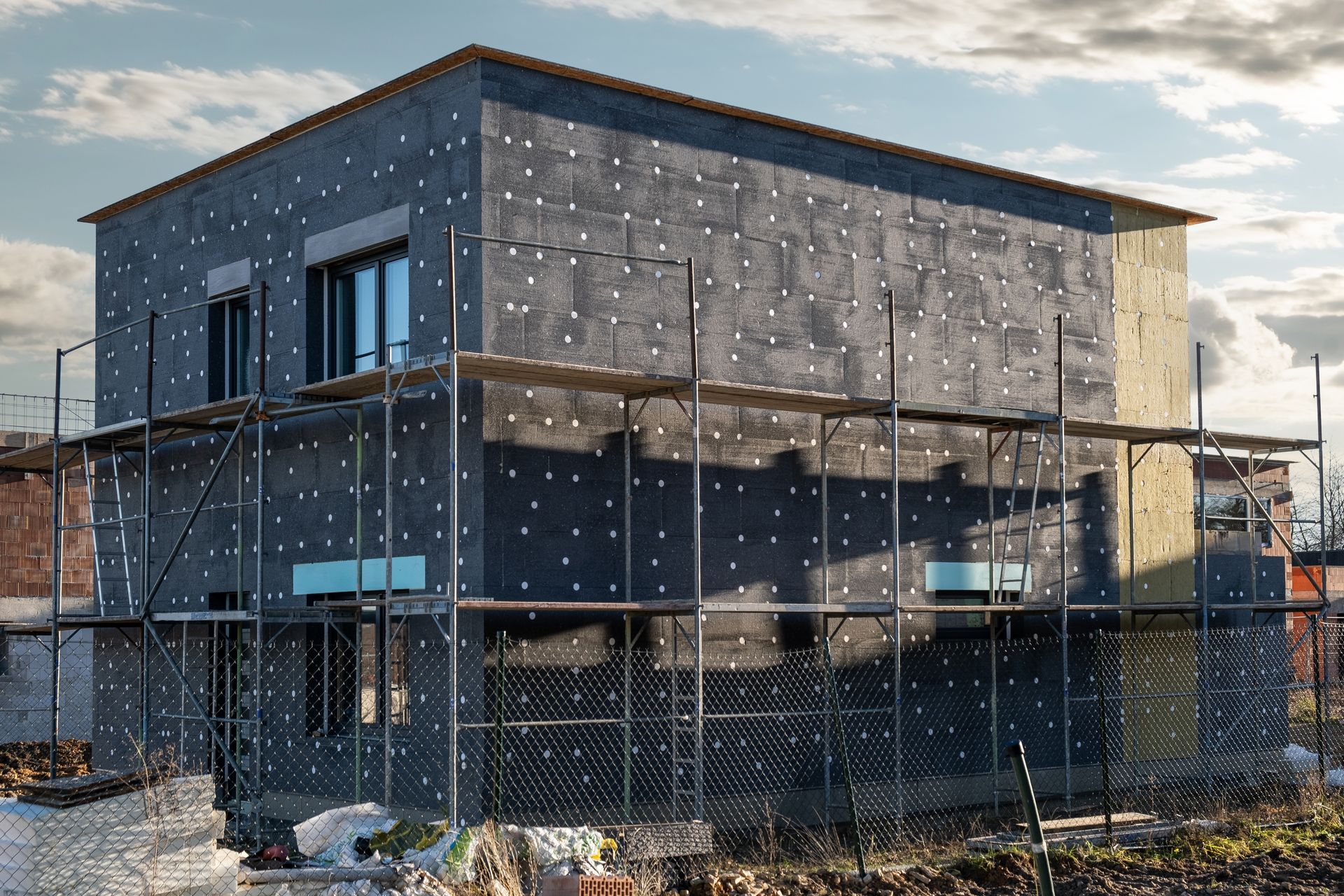 Une maison est en construction avec des échafaudages autour.