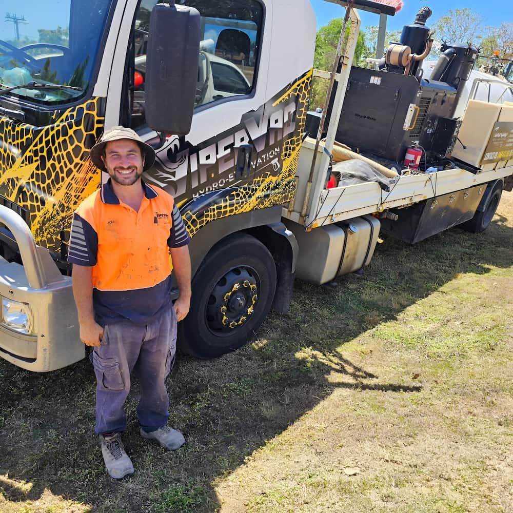 A Man Is Standing In Front Of A Tow Truck — ViperVac Solutions PTY LTD in Cannonvale, QLD