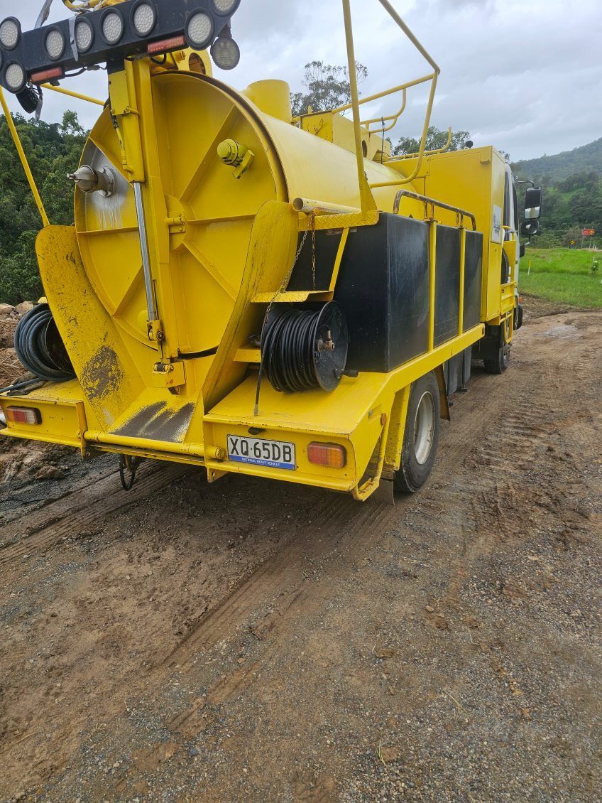 Yellow road marking truck on dirt road — ViperVac Solutions PTY LTD in Cannonvale, QLD