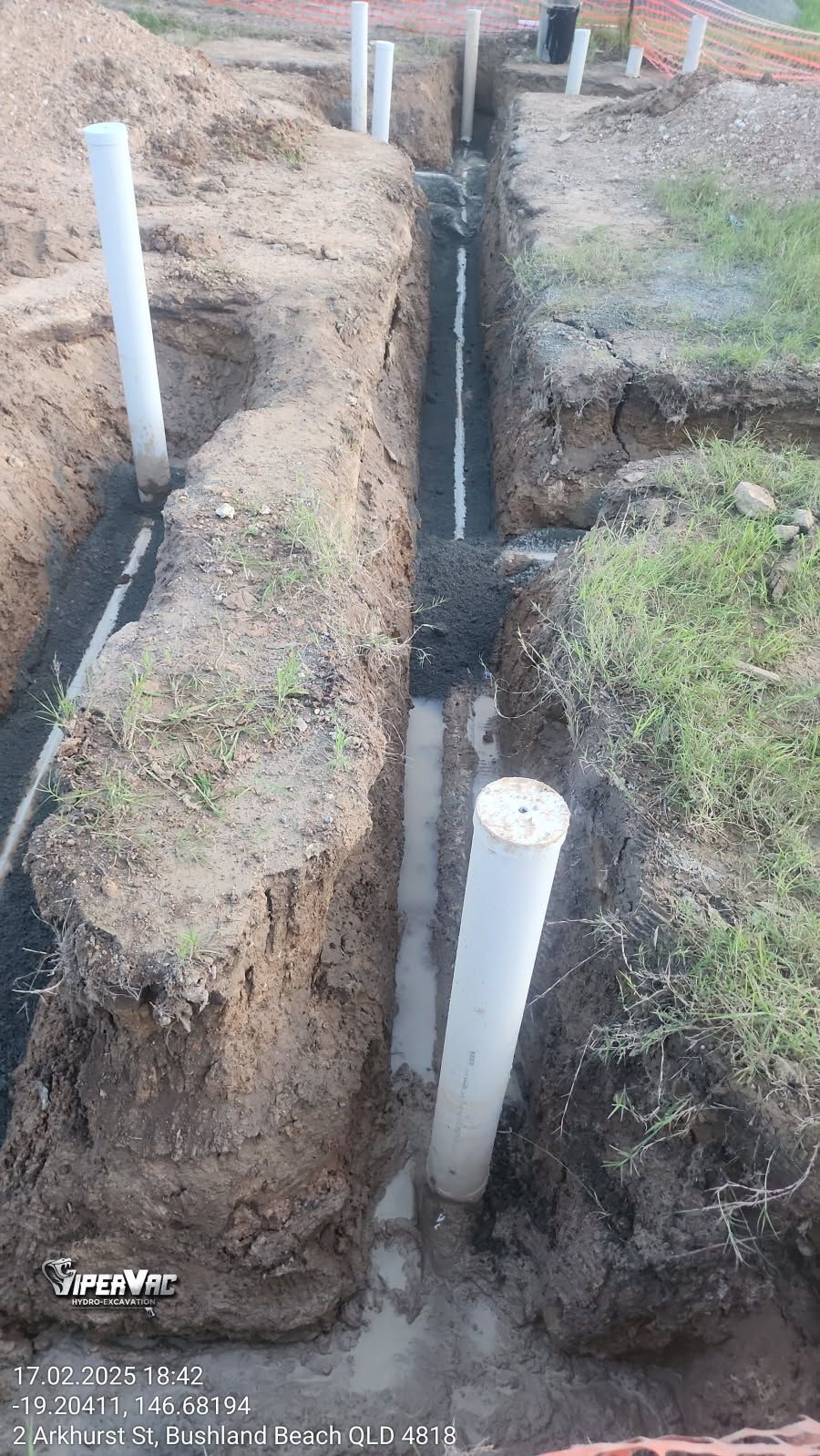 Trenches with white pipes and exposed plumbing in dirt, possibly for a construction project — ViperVac Solutions PTY LTD in Cannonvale, QLD
