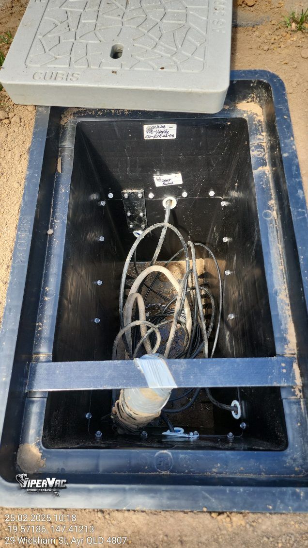 Open black utility box with tangled cables and a gray lid on the ground — ViperVac Solutions PTY LTD in Cannonvale, QLD