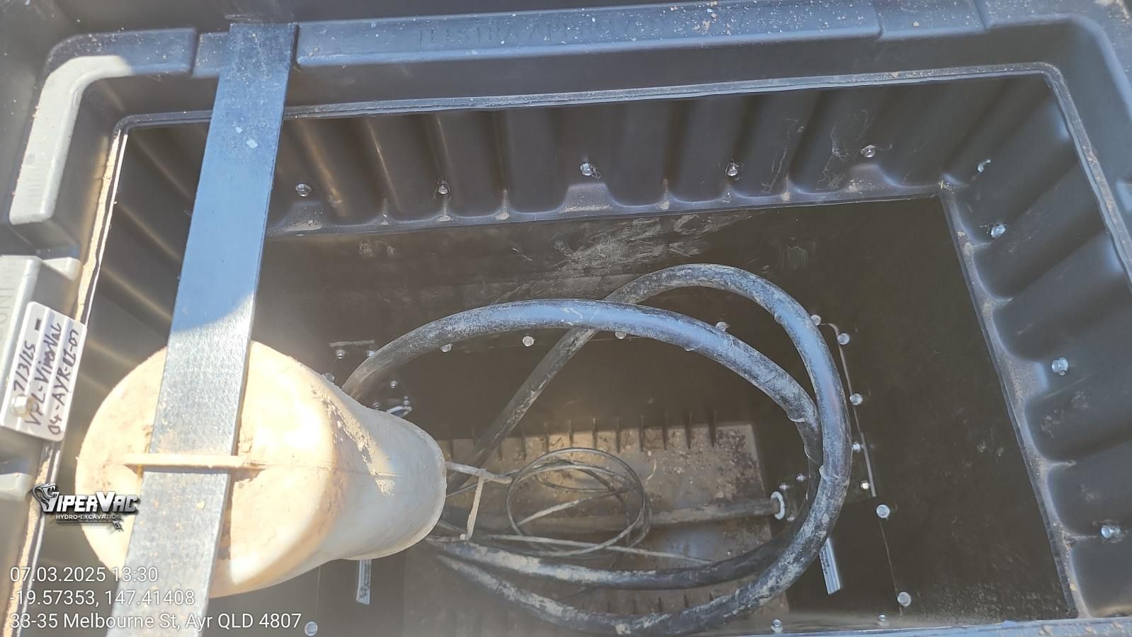 Open black box with a cylindrical object and coiled black hoses — ViperVac Solutions PTY LTD in Cannonvale, QLD