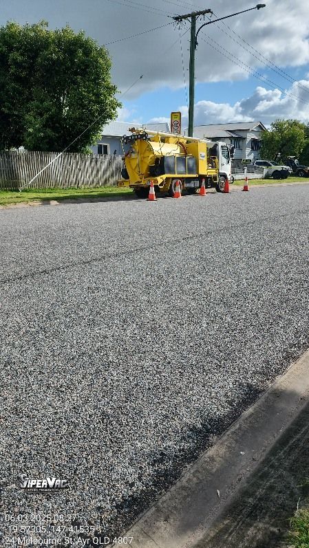 Yellow truck parked on a gravel road, orange cones nearby, utility pole in the background — ViperVac Solutions PTY LTD in Cannonvale, QLD