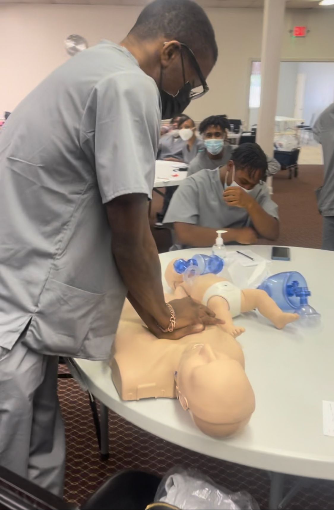 A man is practicing on a baby mannequin