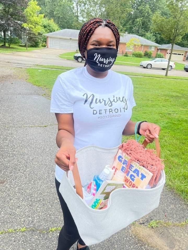 A woman wearing a mask is holding a bag of supplies.
