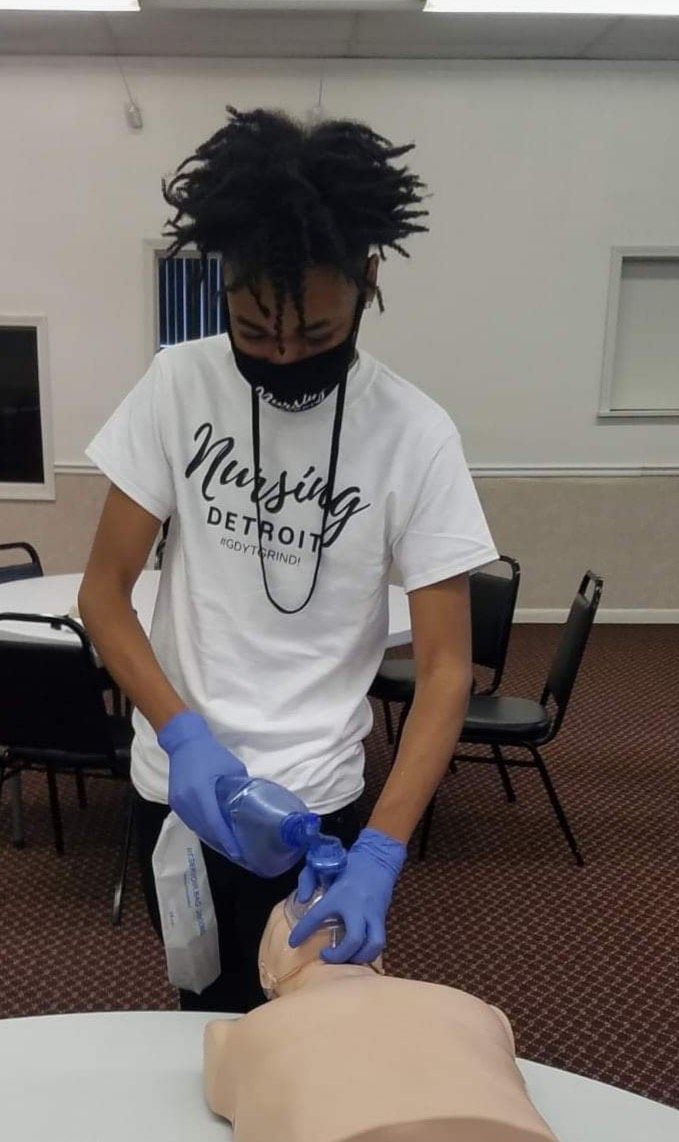 A man wearing a white shirt with the word nursing on it