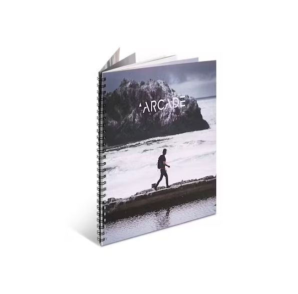 a spiral notebook with a picture of a man walking on a beach