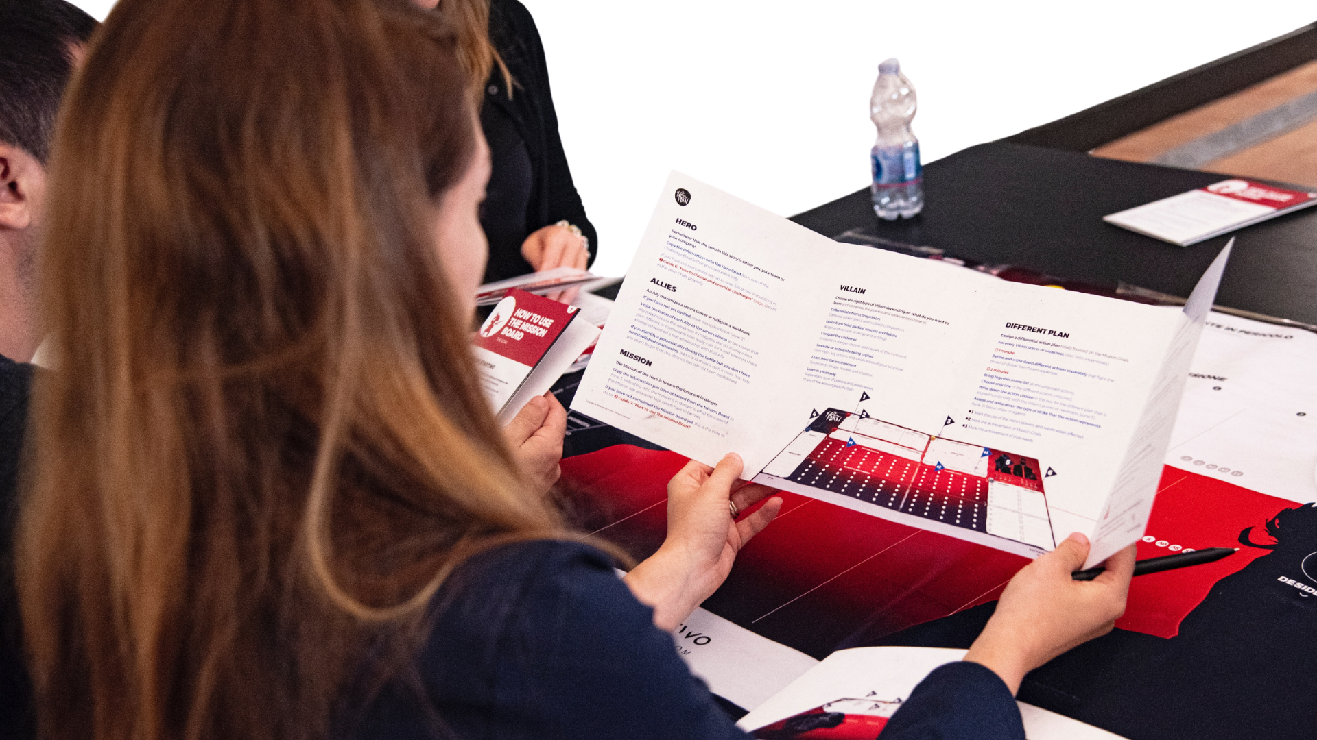 a woman is sitting at a table holding a piece of paper .