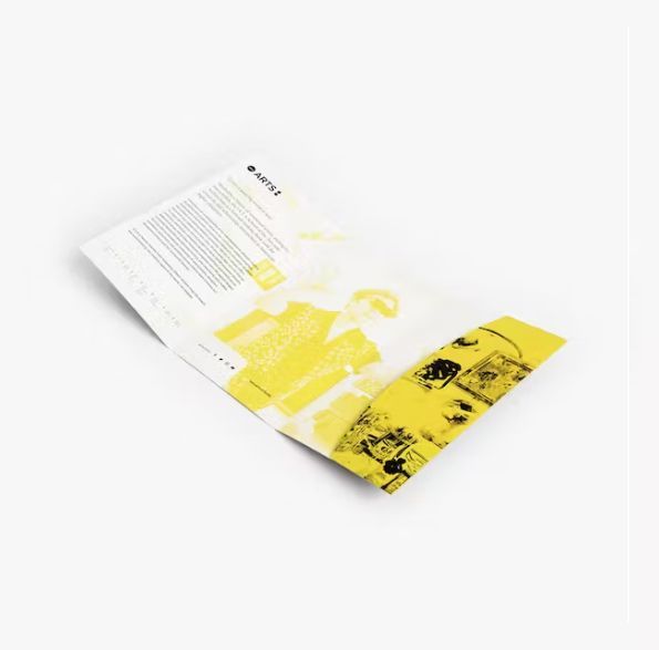 a yellow and white brochure is laying on a white surface