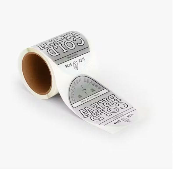 a roll of stickers on a white surface that says `` cold brew '' .