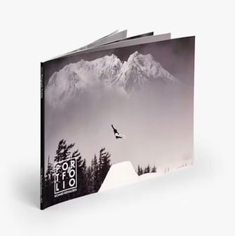 a black and white photo of a snowboarder flying over a mountain .