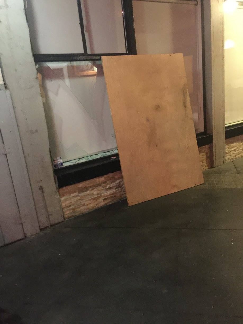 A large piece of wood is sitting on the floor next to a window.