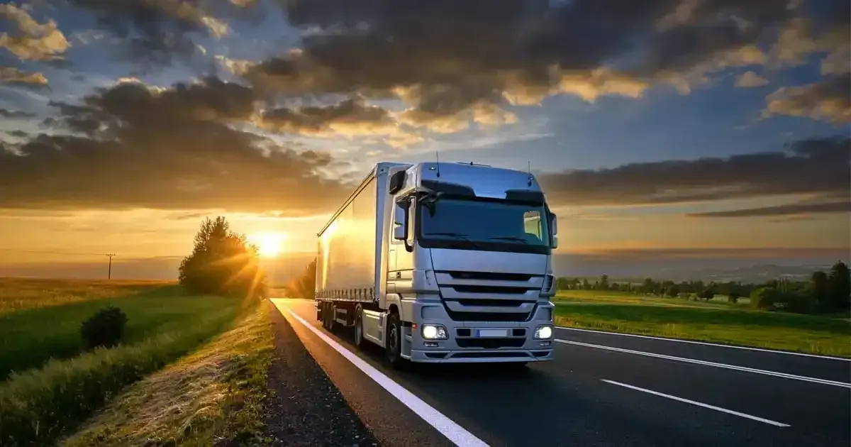 Freight truck driving on highway at sunrise delivering logistics cargo safely