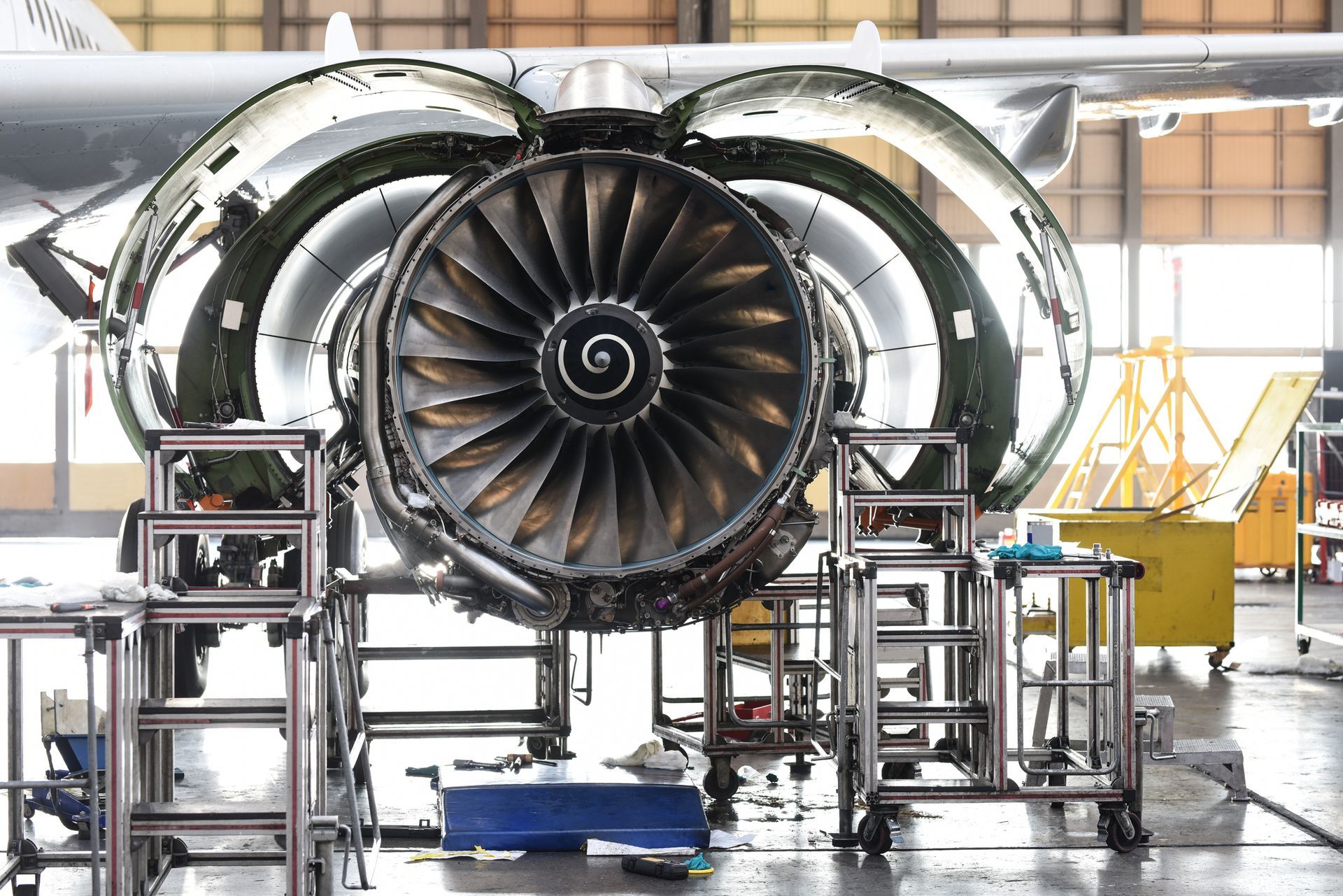 An airplane engine is being repaired in a hangar.