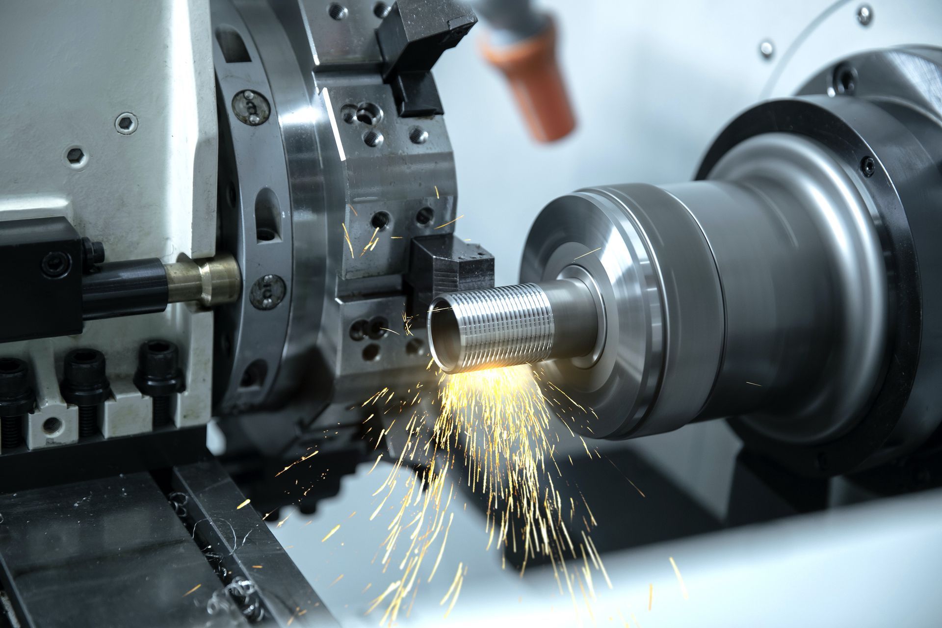 A machine is cutting a piece of metal with sparks coming out of it.