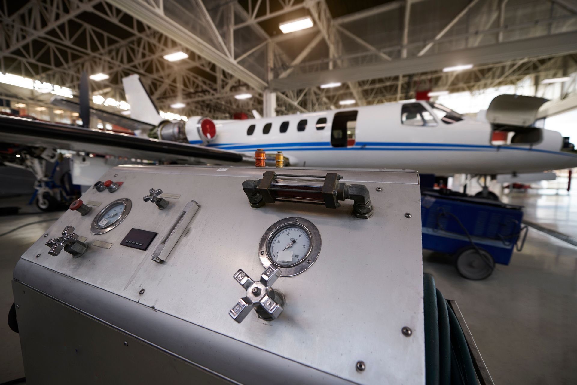 An airplane is parked in a hangar next to a control panel.
