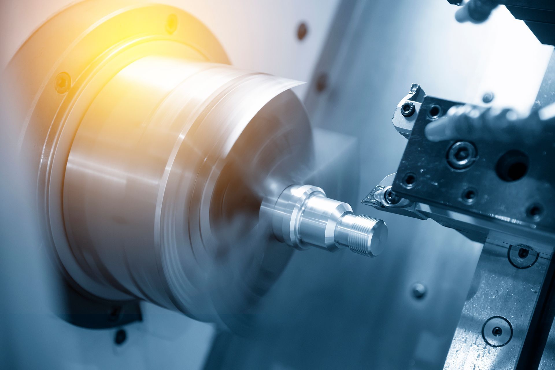 A machine is cutting a piece of metal on a lathe.