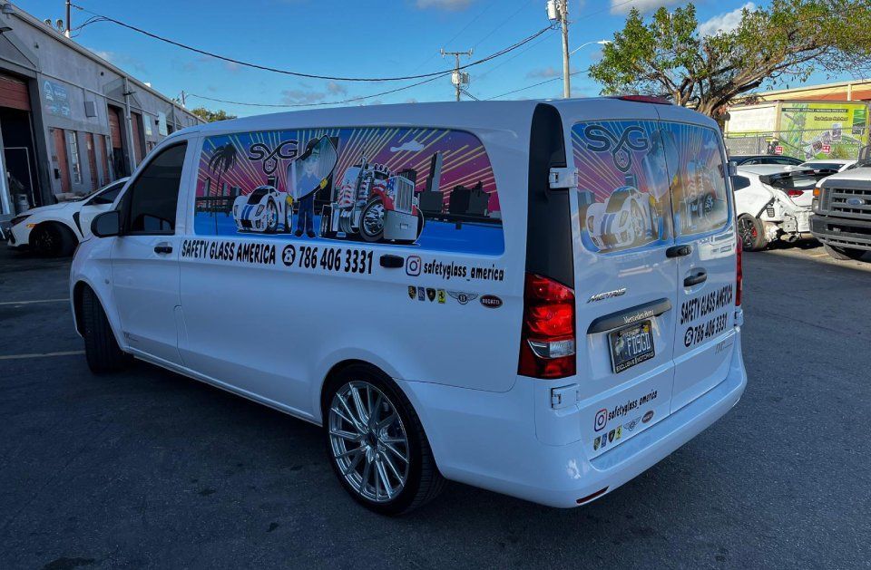 White van with colorful graphics, parked outdoors.