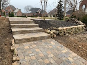 A stone walkway with stairs leading up to a house.