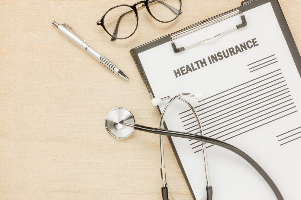 A clipboard with a health insurance form and a stethoscope on it.
