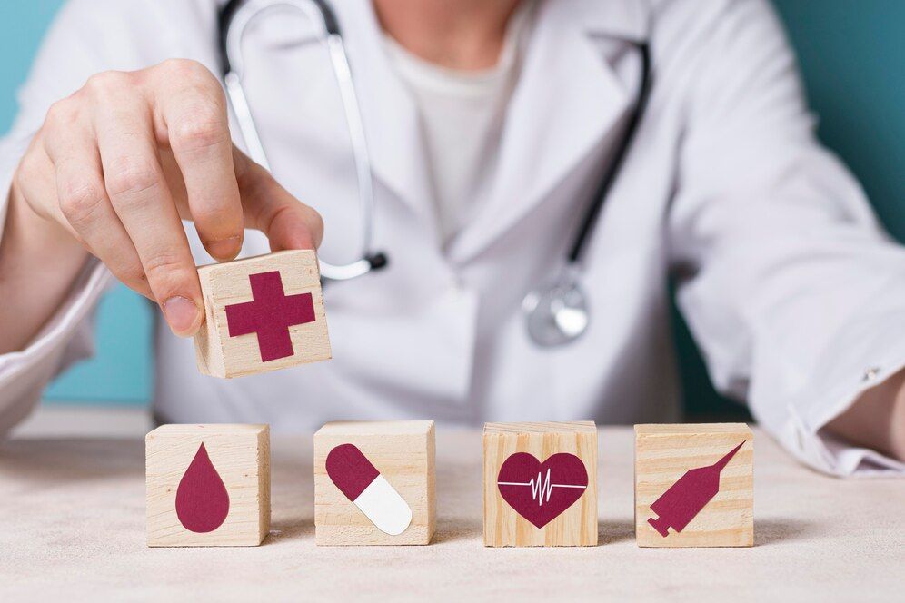 A doctor is holding a wooden block with a cross on it.