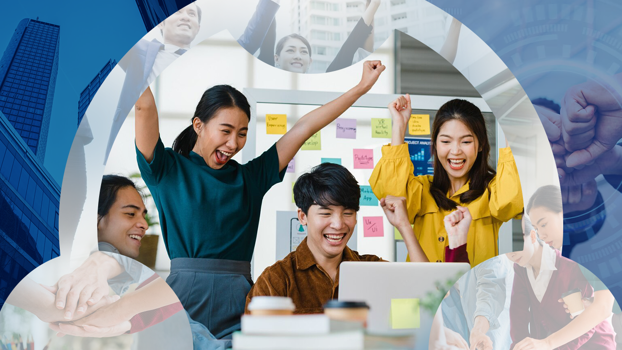Excited office team celebrating success around a laptop in a modern office setting.