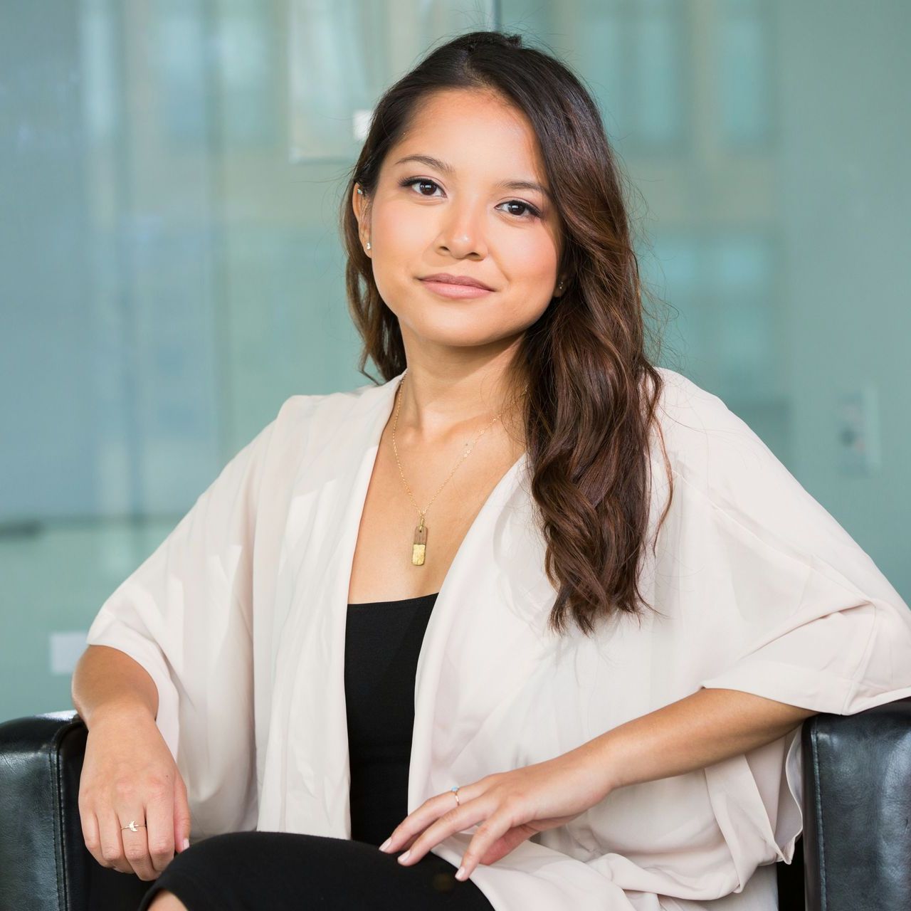 A woman in a white cardigan is sitting in a chair