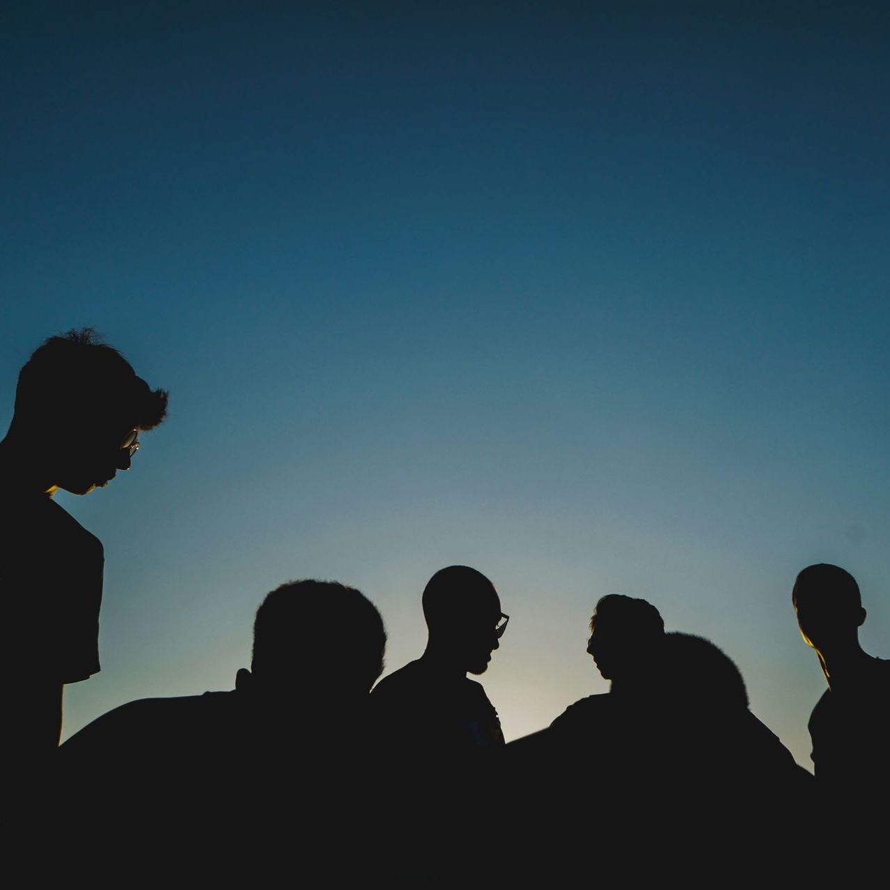 A group of people are standing in front of a blue sky.