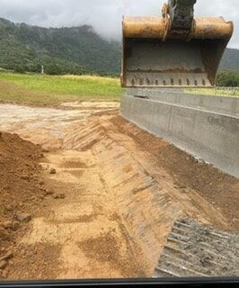 A Bulldozer Is Digging a Hole in The Dirt in A Field — Terranovus Earthworks & Plant Hire in Cairns, QLD