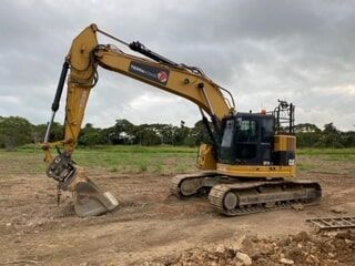 A Large Yellow Excavator Is Sitting on Top of A Dirt Field — Terranovus Earthworks & Plant Hire in Cairns, QLD