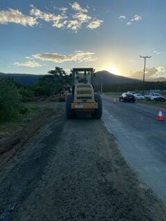 A Bulldozer Is Driving Down a Dirt Road — Terranovus Earthworks & Plant Hire in Cairns, QLD