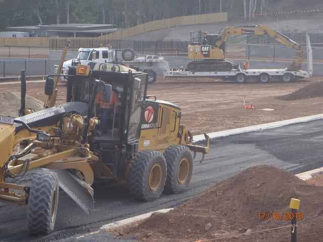 A Man Is Driving a Bulldozer on A Construction Site — Terranovus Earthworks & Plant Hire in Cairns, QLD