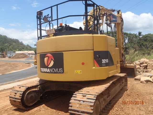 A Yellow Excavator Is Parked on The Side of The Road — Terranovus Earthworks & Plant Hire in Cairns, QLD
