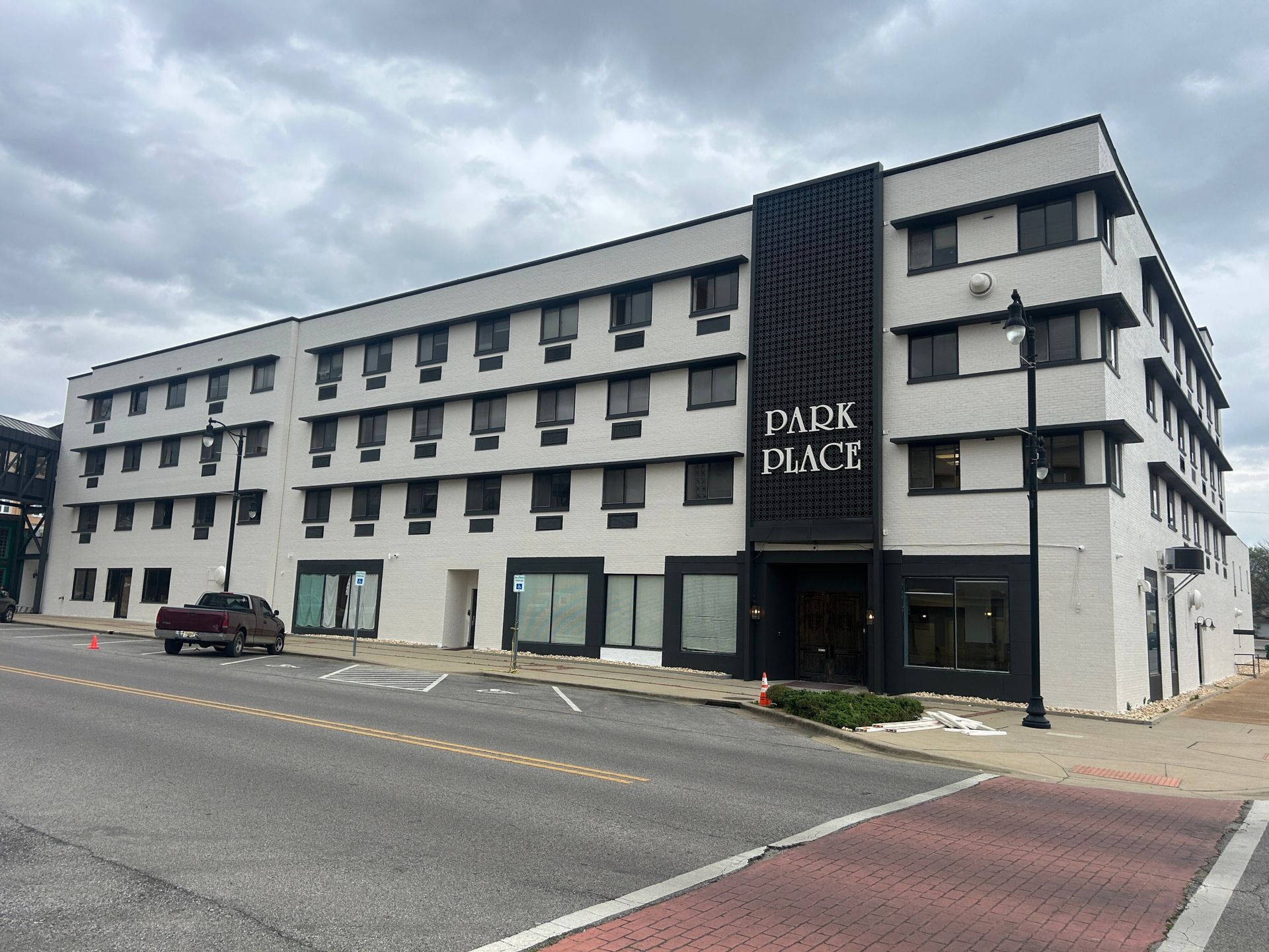 A large white building with a red truck parked in front of it.