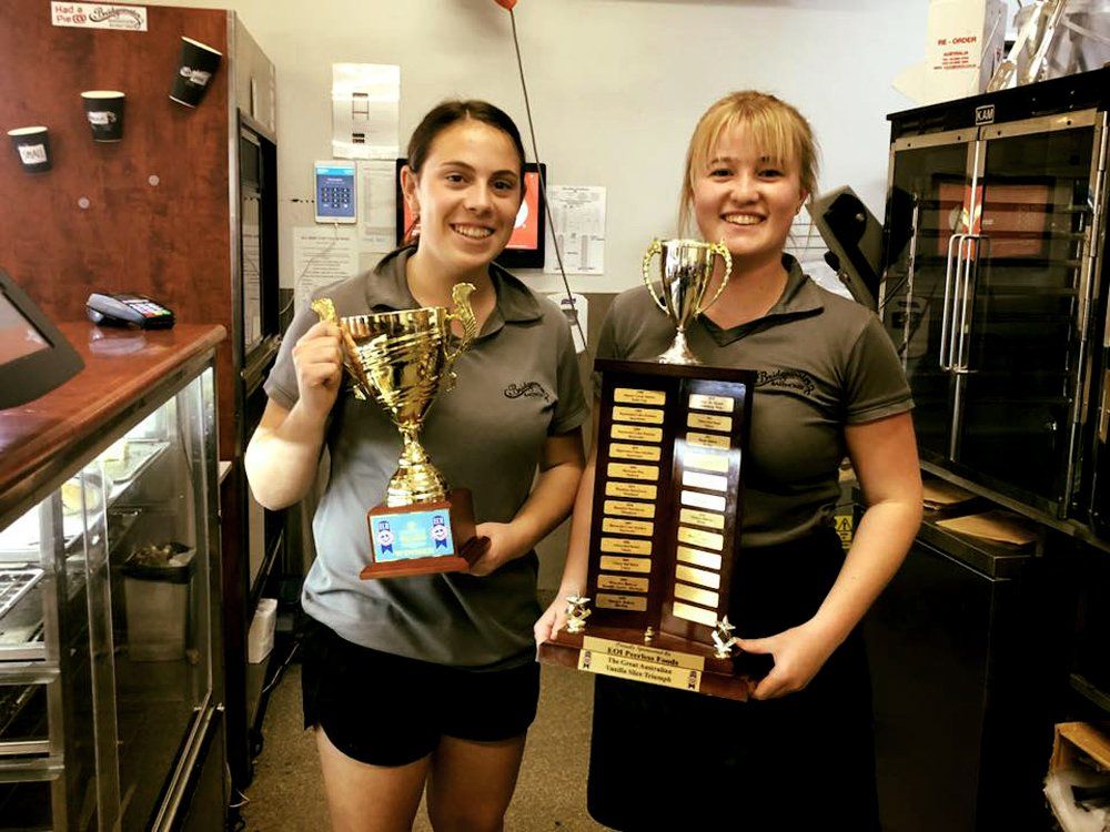 Two girls employee holding trophies
