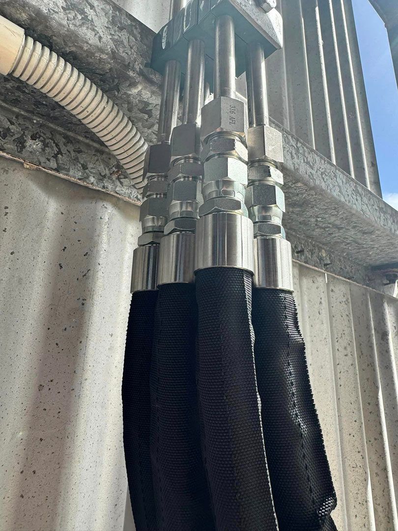 A Bunch Of Hydraulic Hoses Are Attached To A Wall — Townsville Hydraulics In Garbutt, QLD