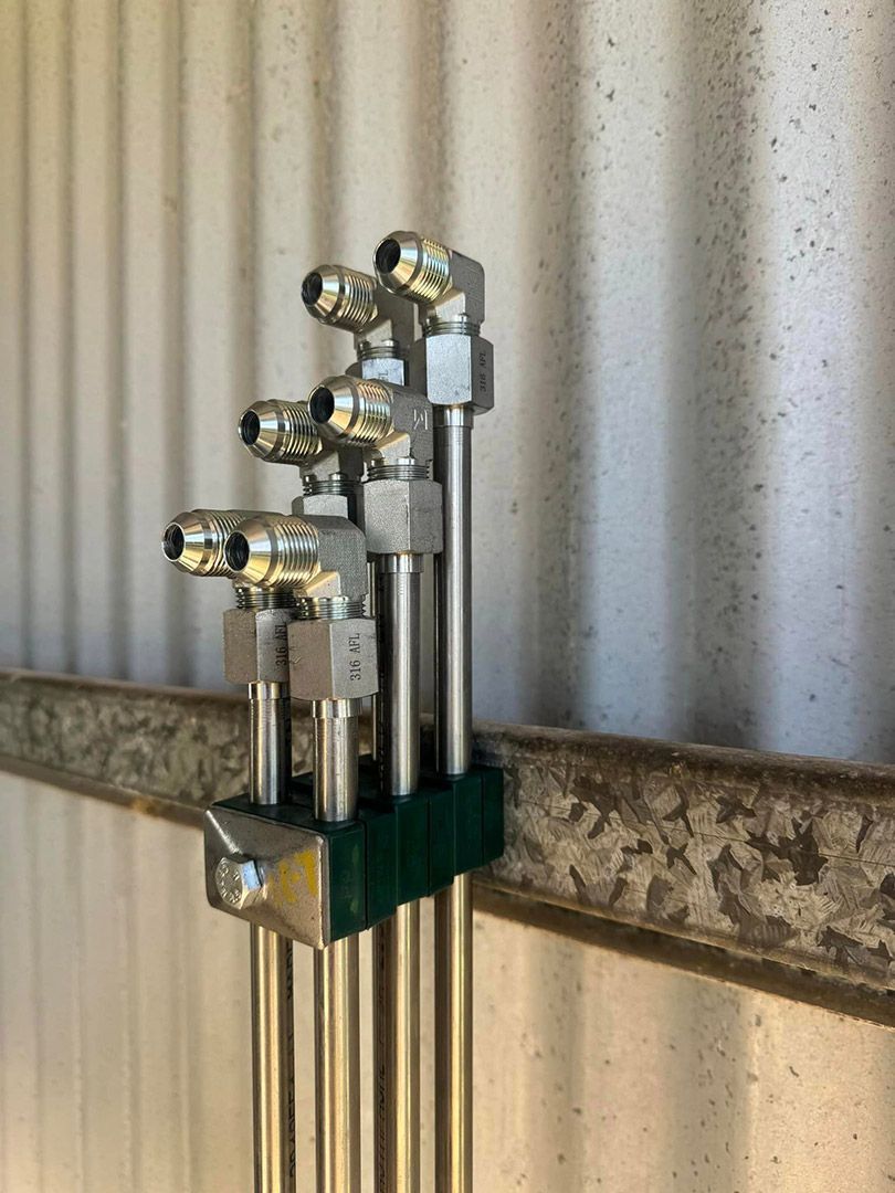 A Bunch Of Metal Pipes Are Sitting On Top Of Each Other On A Wall — Townsville Hydraulics In Garbutt, QLD