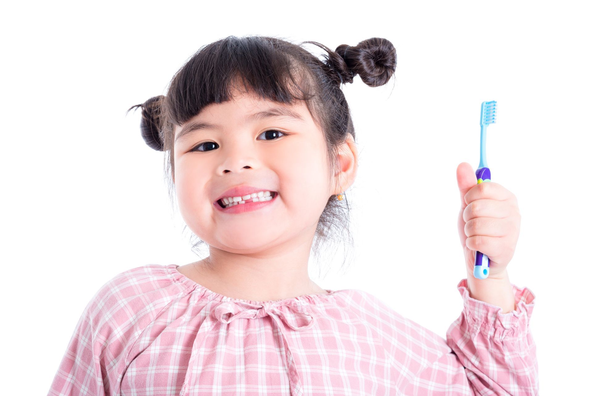 Little asian girl holding toothbrush and smiles over white background
