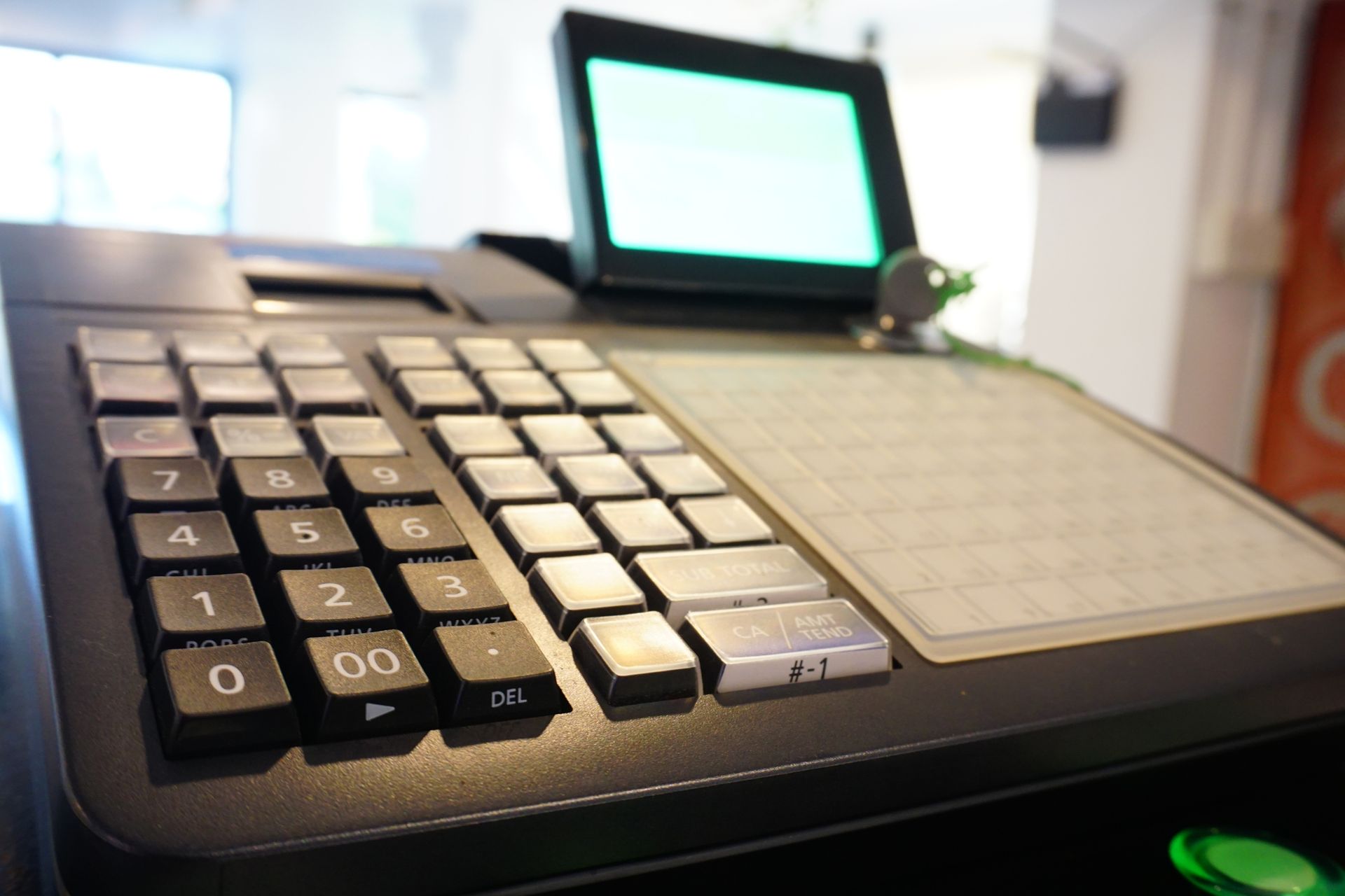 Un primo piano di un registratore di cassa con una luce verde accesa