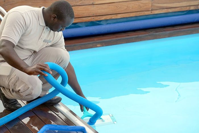 man doing pool maintenance cleaning