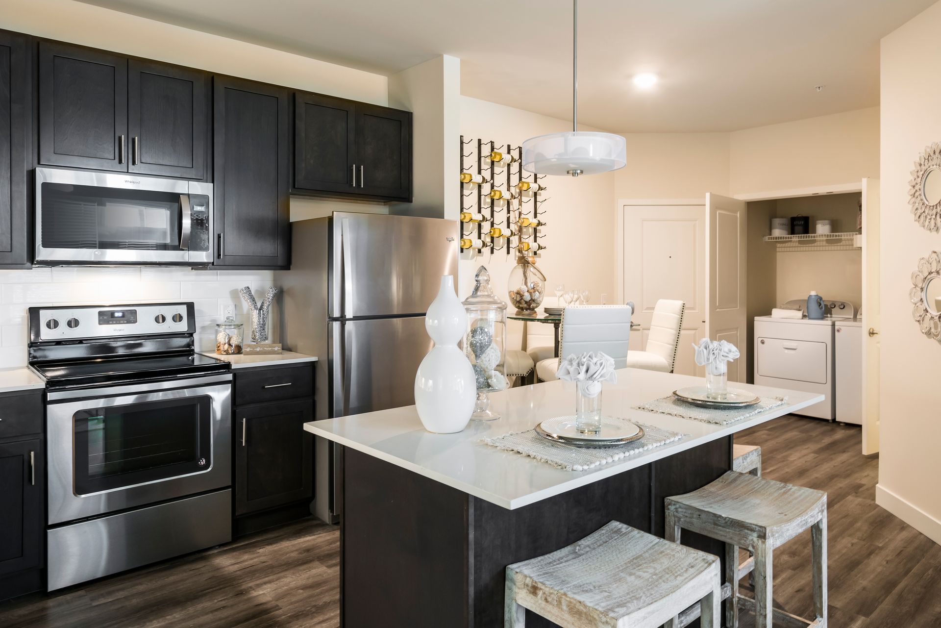 Modern kitchen with dark cabinets, stainless steel appliances, and an island with seating.