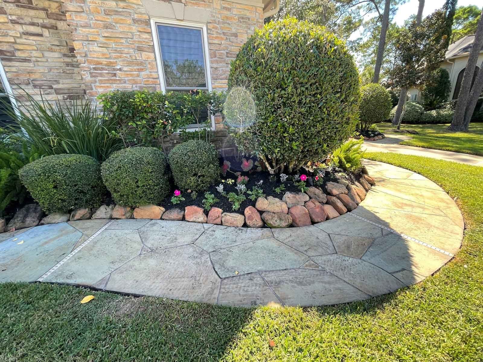 Stone Walkway Surrounded By Bushes And Rocks — Houston, TX — B.E Lawn Services
