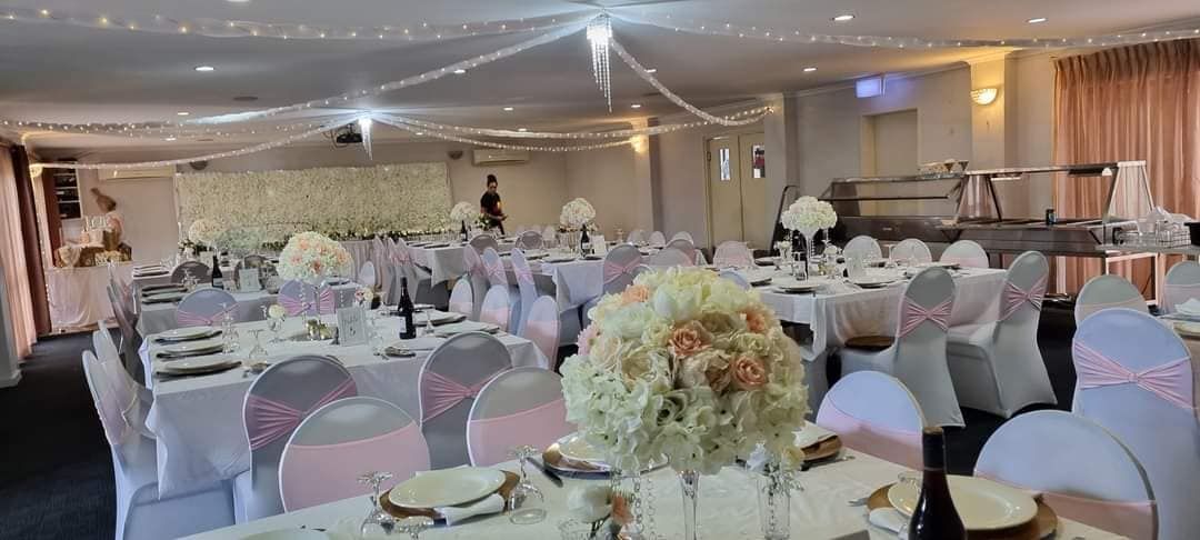 Wedding Reception Hall Decorated With Tables, Chairs and Floral Centerpieces — Creative Events Innisfail in Innisfail, QLD