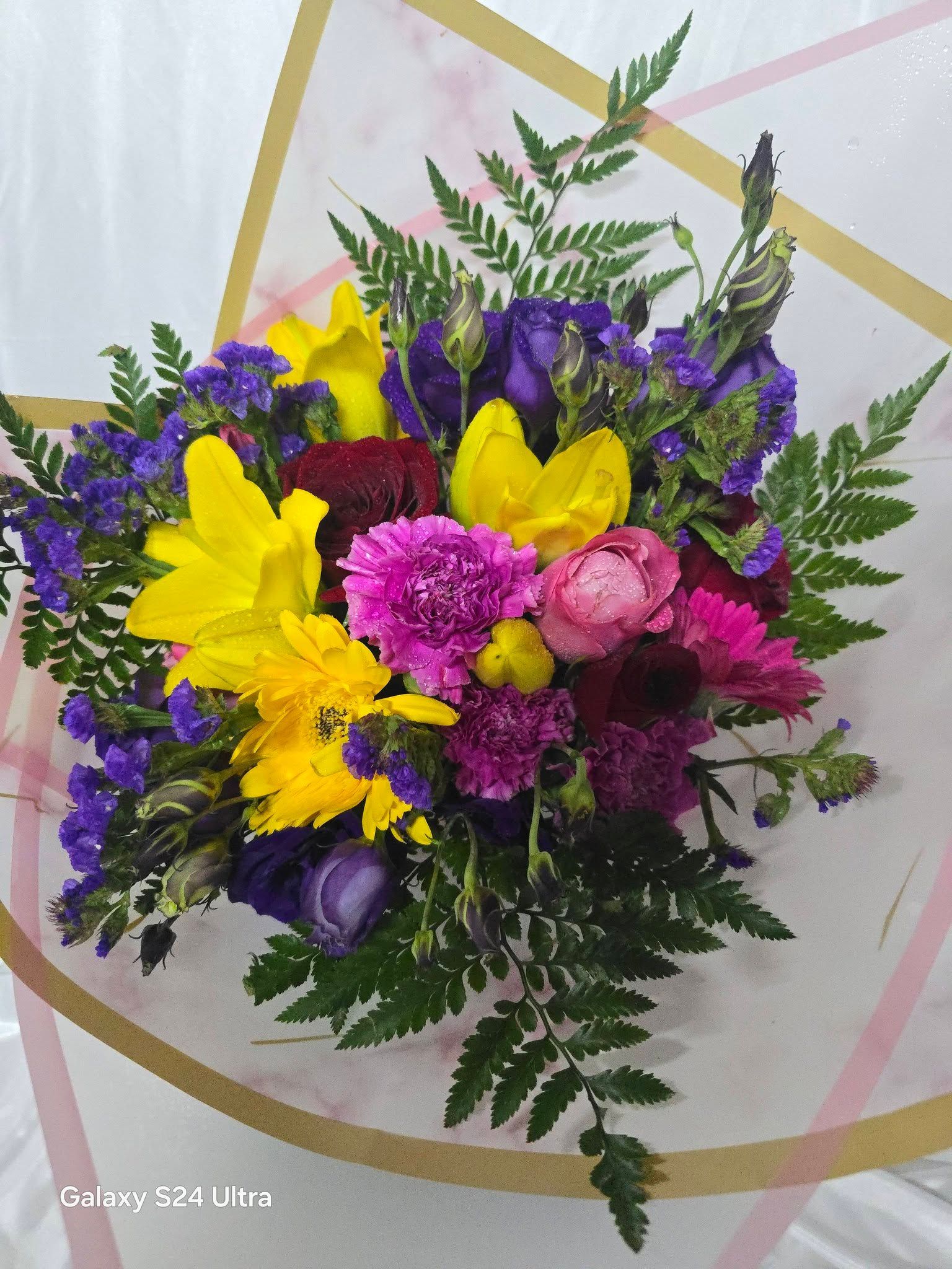 Bouquet of Yellow, Purple, and Pink Flowers Wrapped in Decorative Paper — Creative Events Innisfail in Innisfail, QLD