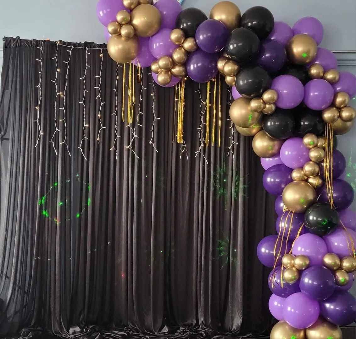 Purple, Gold, and Black Balloon Arch Over Black Curtains — Creative Events Innisfail in Innisfail, QLD